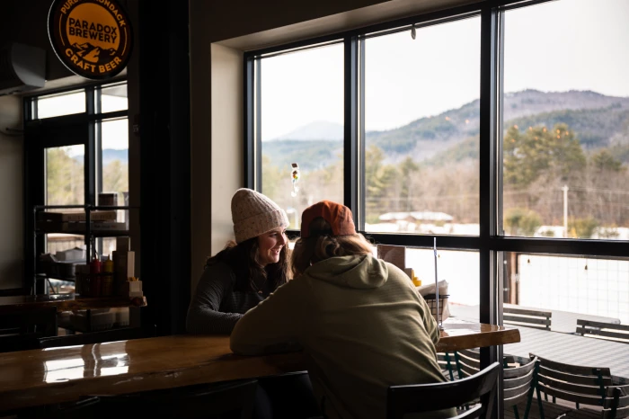 Two people enjoy drinks inside Paradox Brewery