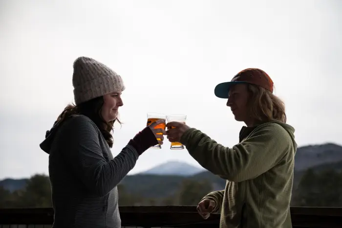 Two people clicking pints together at Paradox Brewery