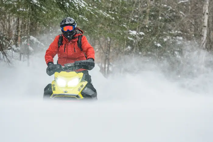 Snowmobiler riding in a plume of snow