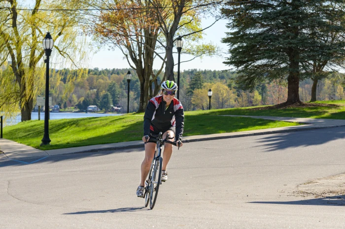 A woman smiles while riding her bike.