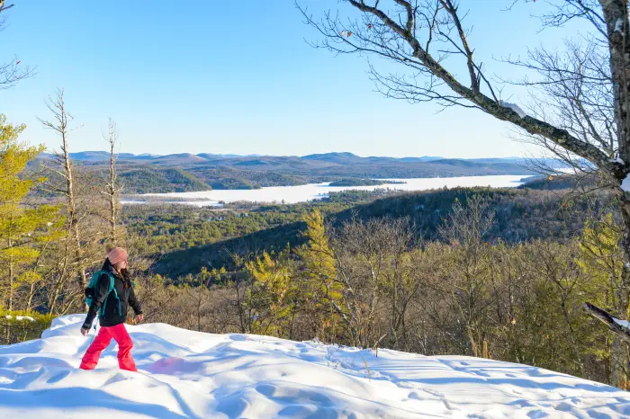 A woman hiking Mount Severance with snowy views and a stunning landscape.