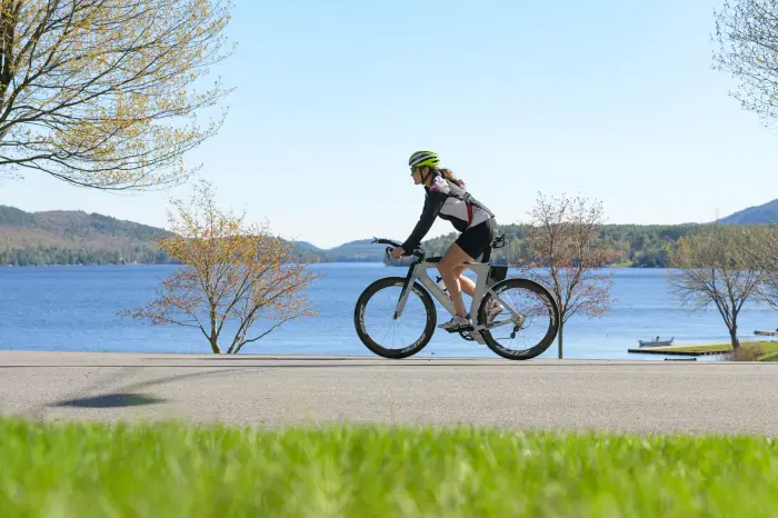 Biking across the road with the Lake next to her