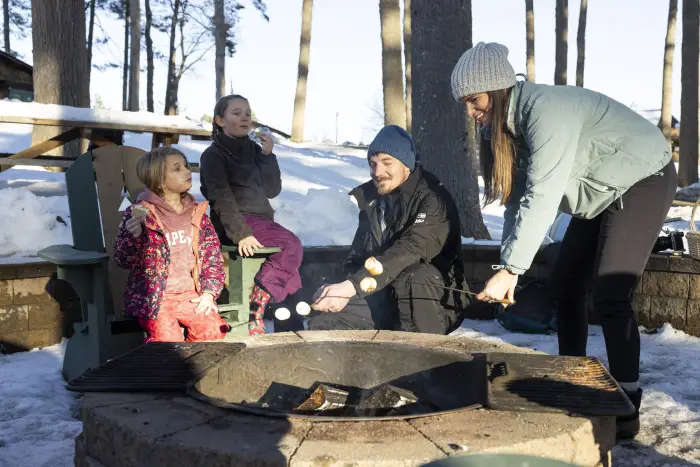 A family roasting marshmallows in the winter