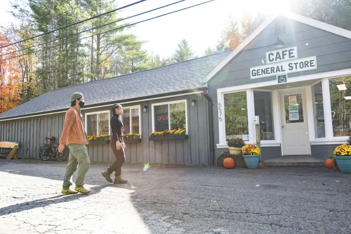 a man and woman walk into the Newcomb Cafe.