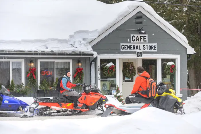 Snowmobilers conversing outside the cafe.