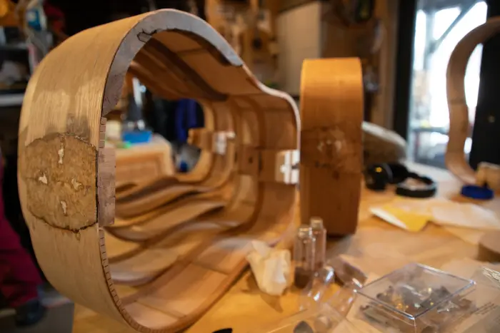 the frame of a handmade guitar on a table.